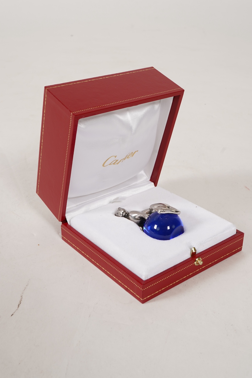 A recent Cartier paperweight, modelled as a panther upon a blue glass sphere